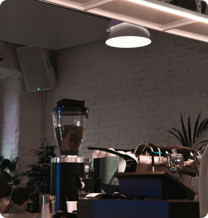 A man and a woman sitting at a counter in a coffee shop drinking coffee over a conversation.